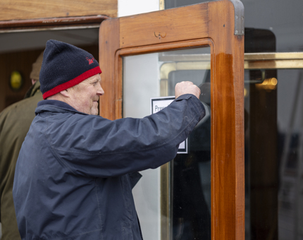 Facilities Officer adding a sign to the windows of the Sunlounge
