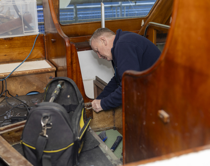 On the Royal Barge, a Maintenance man is installing a seating area. 