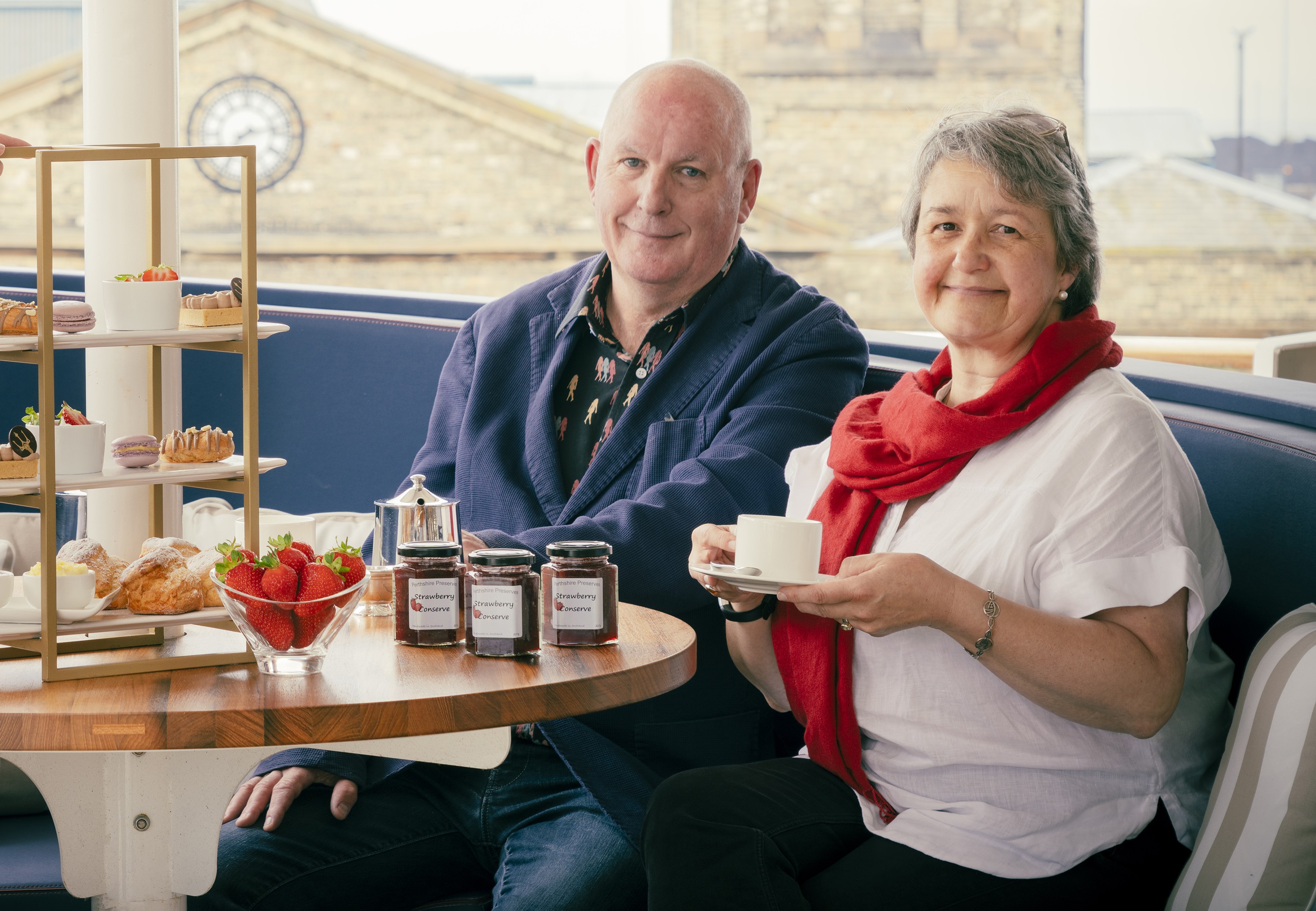 Owners of Perthshire Preserves with jars of their jam and Afternoon Tea stand aboard Fingal