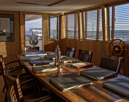 In Fingal's Bridge, large leatherbound log books sit on a long table. The ship's wheel and telegraph are also in the Bridge. 