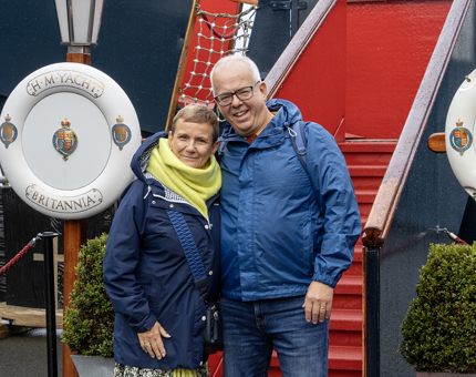 A man and woman standing at the Royal Brow. A Britannia Perrybuoy is behind the couple on the left. 