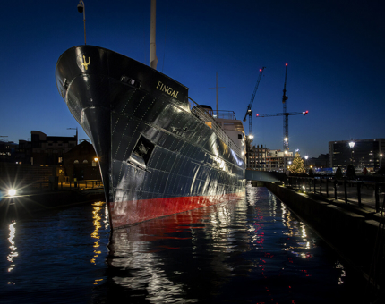 The exterior of Fingal in the evening with a Christmas tree at the brow. 
