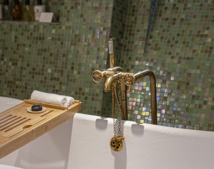The bath and green mosaic wall in a cabin bathroom on Fingal. 