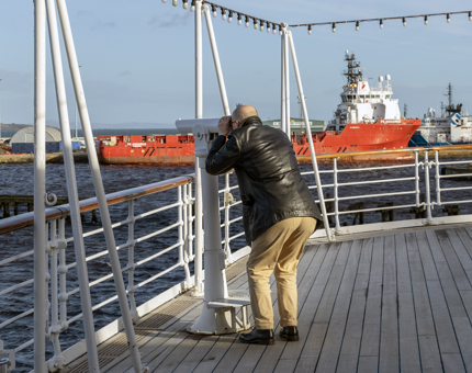Man in black coat and beige pants 