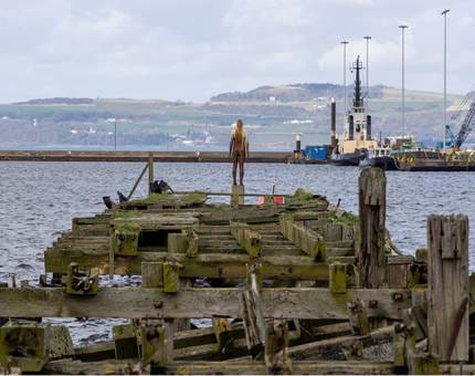 A sculpture of a man at the end of an abandoned pier in Leith. 