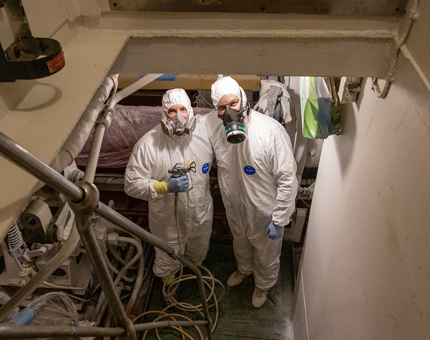 The two team members stop for a moment during the spray painting to pose for a photo.  