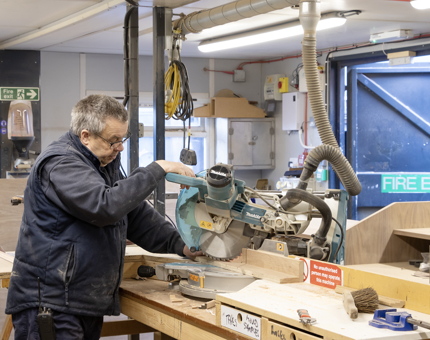 A man from the Maintenance team using a saw cutter to assemble a till point. 