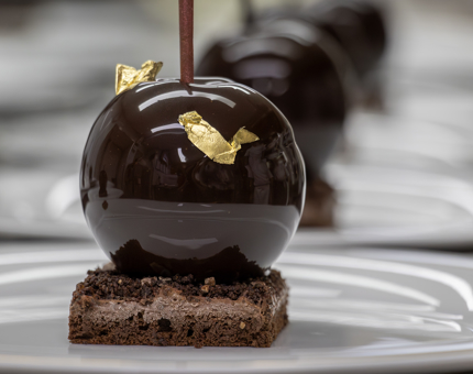 A close-up of a Black Forest Gateau dessert covered with gold leaf decoration. 