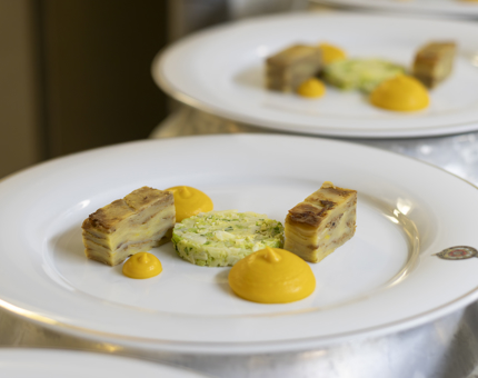 Crested Britannia plates lined up in the Galley, containing carrot puree and potato. 