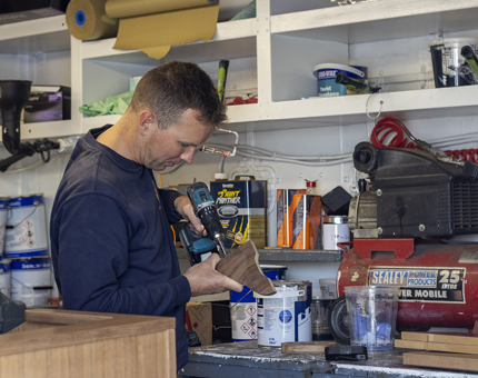 A podium being assembled by a man in a workshop. 