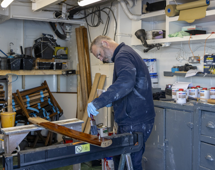 A man varnishing handrails. 