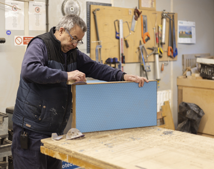 A  Maintenance team member making a step for the Officers' Fast Motor Launch in the Workshop.