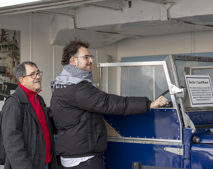 Two visitors taking a photo by the Land Rover. 