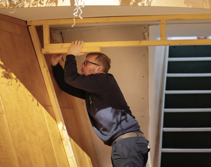 A Maintenance team member building a frame for a doorway. 