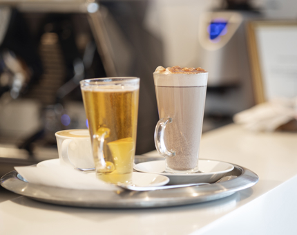 A tray with a hot chocolate and hot toddy waiting to be served. 