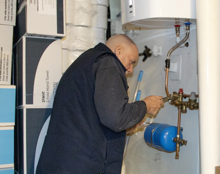 A Maintenance team member performing maintenance on a boiler. 