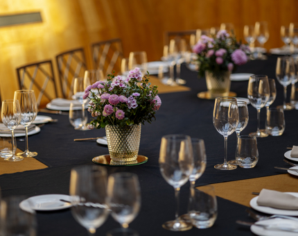 A Long table set for dinner with a blue table cloth in the Ballroom. 