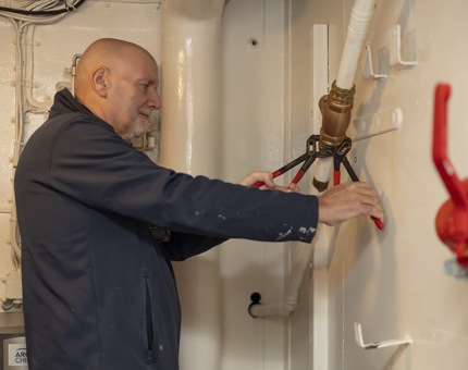 A Maintenance team member installing a return valve. 
