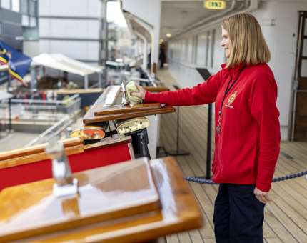 A Housekeeper cleaning the top of the Royal Brow onboard The Royal Yacht Britannia in Leith. 