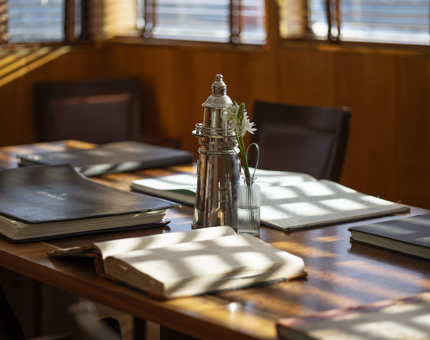 In the Bridge aboard Fingal, The table has log books and a silver lighthouse ornament.