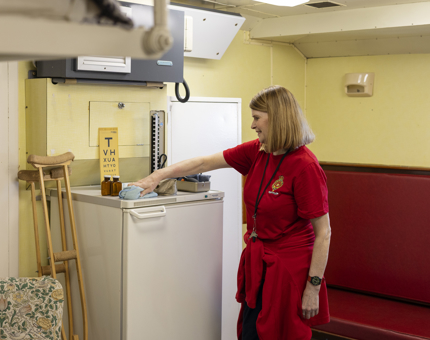 A Housekeeper is dusting in the Sick Bay