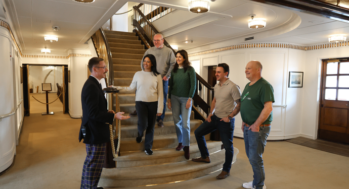 Guests Are Listening To A Tour Guide Aboard The Royal Yacht Britannia in Leith.