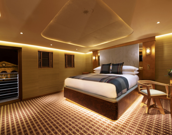 Luxury cabin bedroom aboard Fingal hotel ship with king-size bed and warm interiors, a unique place to stay and visit in Leith near Edinburgh, Scotland