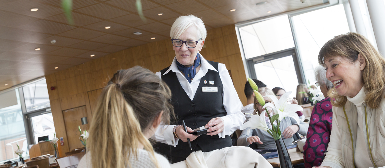 Gayle, Waiter, provides table service in the Royal Deck Tea Room.