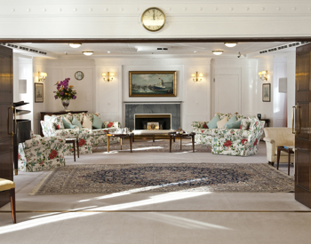 Elegant drawing room with floral sofas and fireplace on a historic ship, one of the classic Edinburgh attractions and sights to visit offering private hire tours