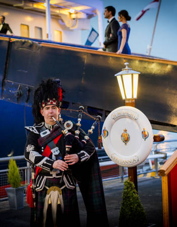 Piper playing outside The Royal Yacht Britannia