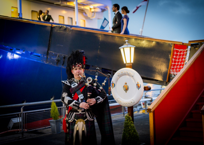 Piper playing outside The Royal Yacht Britannia