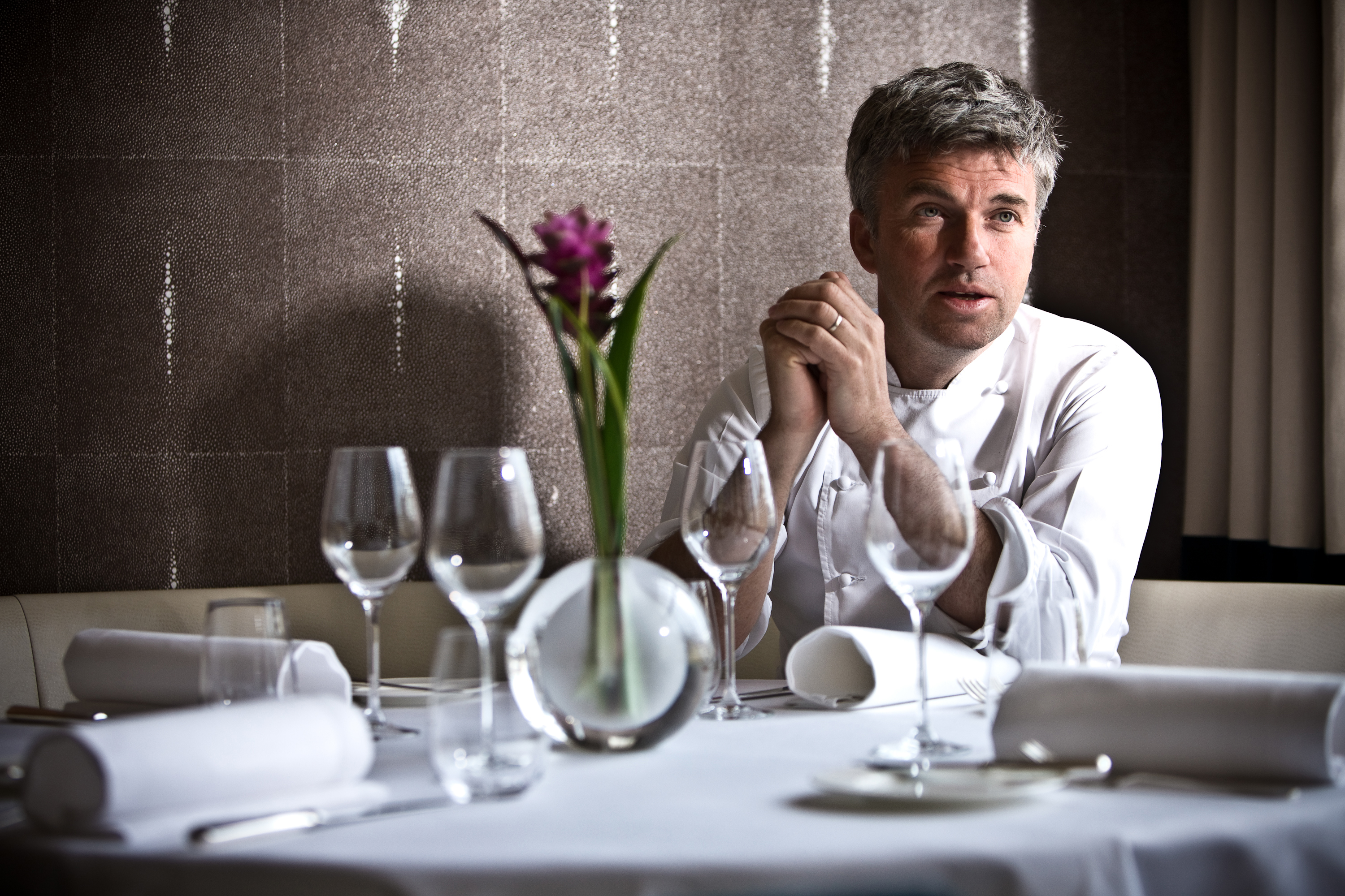 Chef Martin Wishart sitting at a table in a restaurant. 