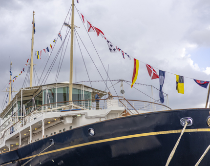 A view of the Bow of The Royal Yacht Britannia with colourful dress flags strung above. 