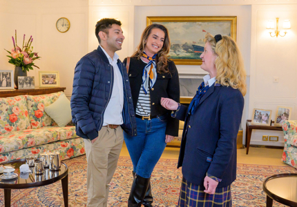 A man and a woman talking to a Visitor Assistant in the Drawing Room.