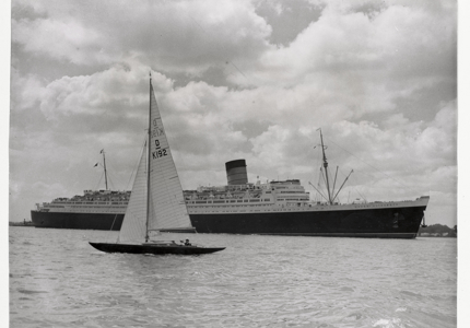 sail boat in foreground of a ship