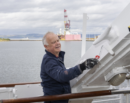 A maintenance man Painting Davit At the Garage onboard Britannia. 