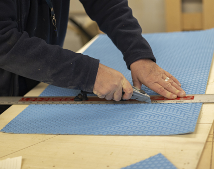 A close up of hands cutting non-slip treading