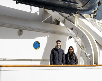 Two visitors standing on the decks of The Royal Yacht Britannia. 
