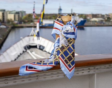 A Britannia Silk Scarf tied to a railing on deck in the Port of Leith. 