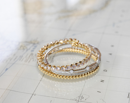 A stack of gold and silver bracelets with enamel and diamante detailing 