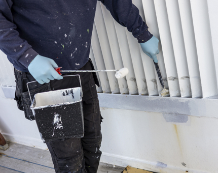 A closer look at a maintenance man adding a coat of white paint to a wall along Britannia's tour route. 