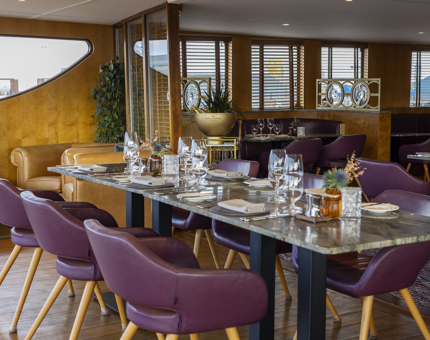 In The Lighthouse Restaurant & Bar a table is set for 6 people for dinner. 