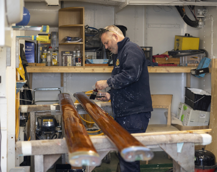 A Maintenance team member varnishing handrails. 