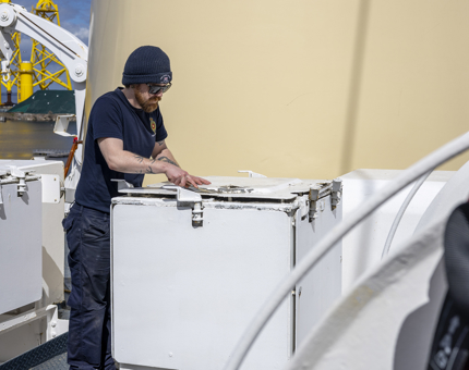 A man from Maintenance is painting the boat deck. 