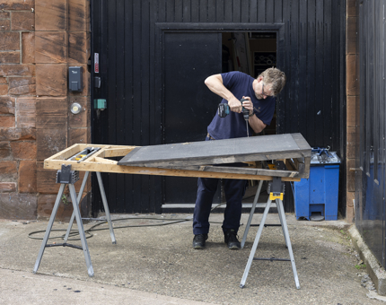 A Maintenance man making A Ramp For The Laundry Store Container at Fingal Hotel in Leith. 
