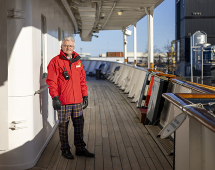 A Visitor Assistant standing on the deck of The Royal Yacht Britannia in Leith. 