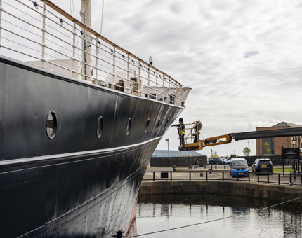 A member of the Maintenance team is painting the outside of Fingal's hull while on a cherry picker. 