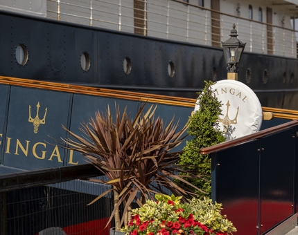 The entrance gangway to Fingal Hotel. It has plants and a perry buoy next to it.