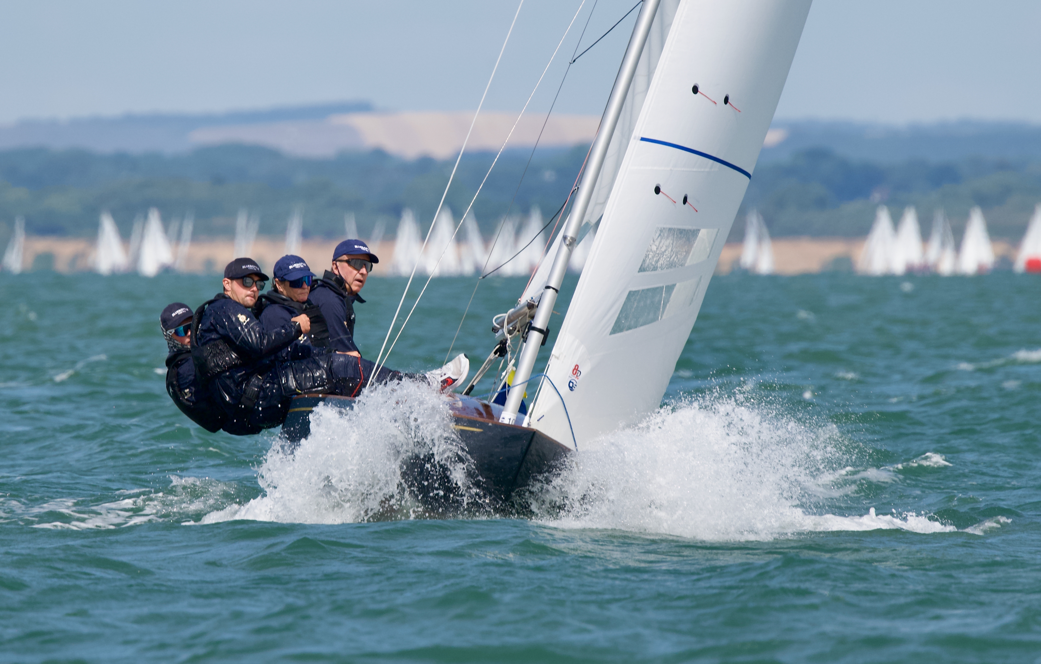 A crew sailing a sailboat on rough seas 