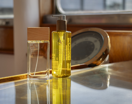 A bottle of yellow hand soap and a bottle of eau de toilette. 